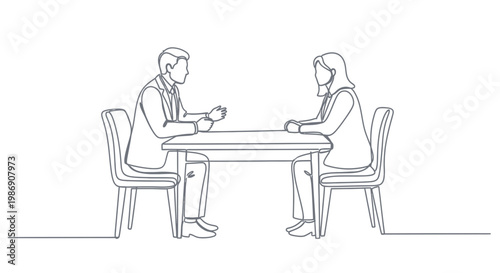 Two people sitting at a table discussing papers in an office