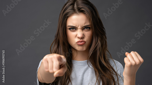Furious Expression A woman with an intense gaze and clenched fist, points directly at the viewer, conveying raw anger and frustration, emotions etched vividly across her face.
