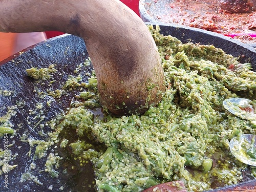 Foto Green chilies are being ground to complement Sundanese food