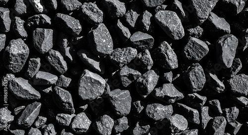 Close-up overhead view of a pile of dark, rough, and textured black coal rocks