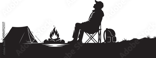 Silhouette of a camper sitting by a campfire with a tent and backpack