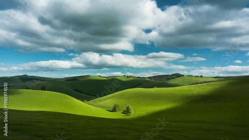 Time-lapse of cloud shadows moving across rolling green hills in bright daylight