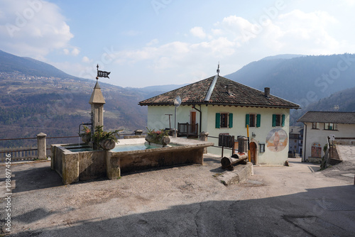 Alpine village historical fountain with mountains and sky