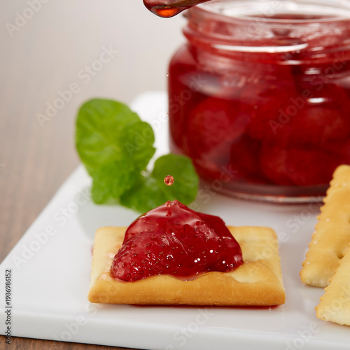 ツヤのある美味しそうないちごのコンフィチュールとクラッカーのイメージ