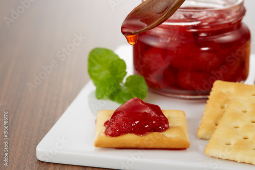 ツヤのある美味しそうないちごのコンフィチュールとクラッカーのイメージ