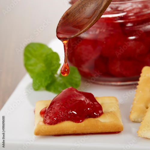 ツヤのある美味しそうないちごのコンフィチュールとクラッカーのイメージ