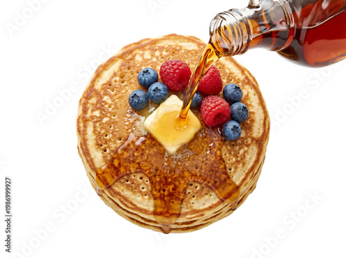 top view of pancakes stacked with syrup frozen mid pour isolated on pure white background high speed food photography composition