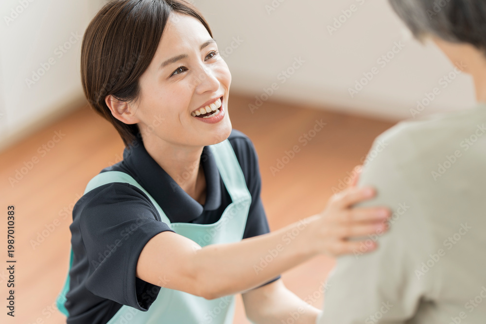 Fototapeta premium 高齢者を介助する女性介護スタッフ