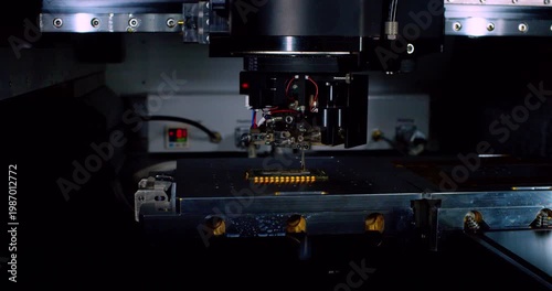 High-tech production.A modern industrial robot for electronics manufacturing makes a complex printed circuit board.Close-up.