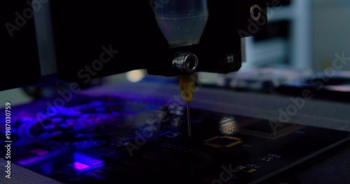 A close up view of automated machinery inserting components onto a circuit board during the manufacturing process. Robotic assembling microchip. Closeup shot.
