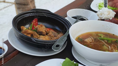 Vietnamese combo lunch and traditional cuisine show clay pot fish with tasty soup. Fresh rice and healthy ingredients create a balanced meal at the restaurant. Every vietnamese combo lunch task.