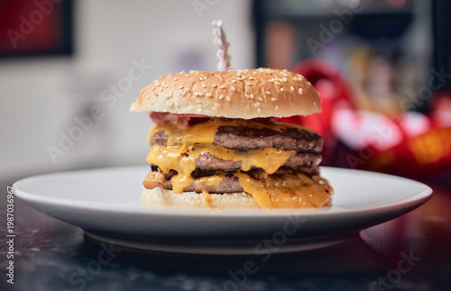 Close up of a cheeseburger in a takeaway container set on a black and white checkered tablecloth, with warm golden bun tones and melted cheese. Classic uk cafe culture.