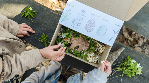 Children exploring nature's treasures in a discovery box with illustrated guide