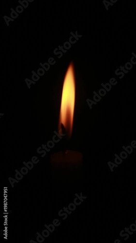 A macro shot of a flickering candle flame against a dark background, conveying a warm and cozy ambiance, loopable, looping