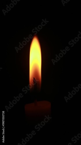 A close-up macro shot of a flickering candle flame against a dark background