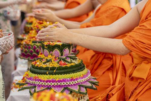 Fotografía Asian monk pouring water blessing flower arrangement festival orange robe religi