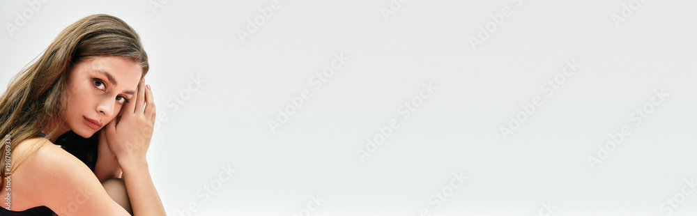 Fototapeta premium Captivating young woman showcasing beauty and elegance in a minimalist modern setting