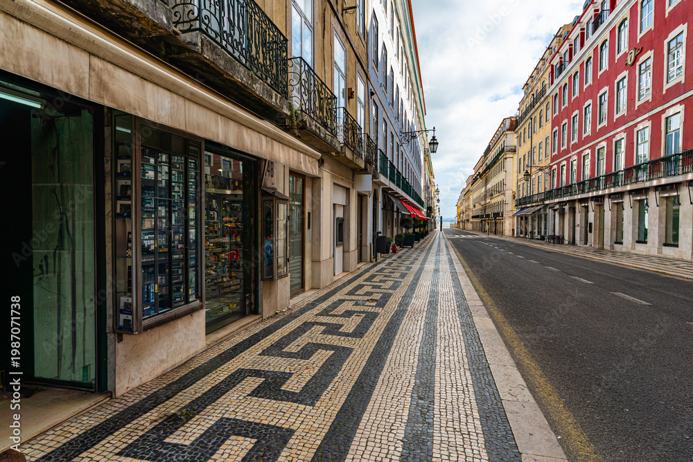 Fototapeta premium Traditional Lisbon street with souvenir shop display Portuguese mosaic pavement and historic colorful buildings in city center travel destination concept
