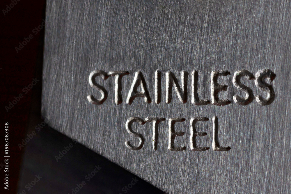Fototapeta premium Stainless steel text engraved on brushed metal surface