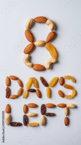 A creative arrangement of nuts and dried fruits spelling out eight days left on a plain background