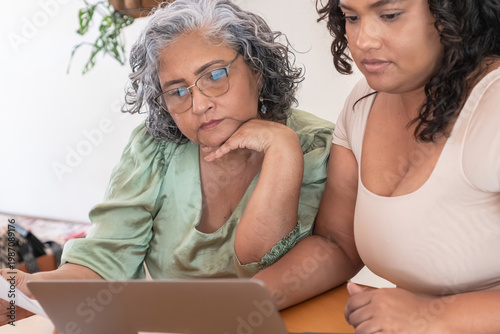 Senior woman and caregiver reviewing long-term care finances