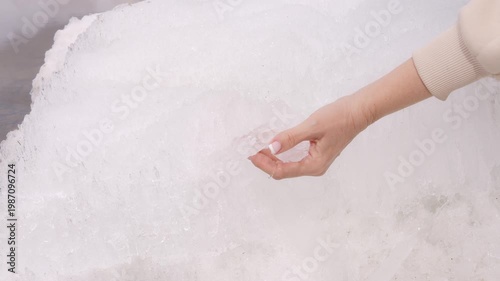 Cold therapy concept hand touching ice surface cold sensation awakens skin cold exposure boosts circulation and energy macro shot of frozen texture sensory experience wellness and recovery ritual