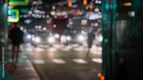 Pedestrians crossing busy urban night street, defocused static view.