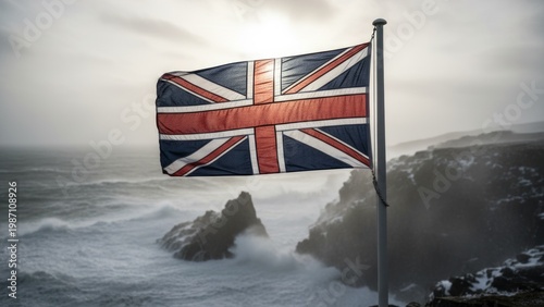 Photograph of the British flag flapping in the wind atop a rocky cliff, overlooking a stormy, turbulent ocean with crashing waves.