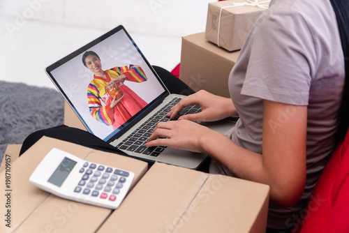 E-commerce in Traditional Style: A person manages her online business, blending modern technology with a touch of tradition, using her laptop while surrounded by parcels and a calculator.