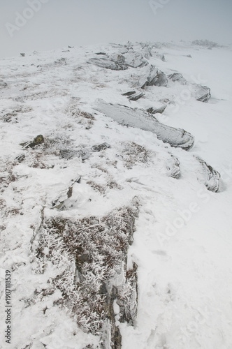 Snow-covered frozen rocky plateau on top of Big Nurgush mountain range in winter, South Ural, Russia