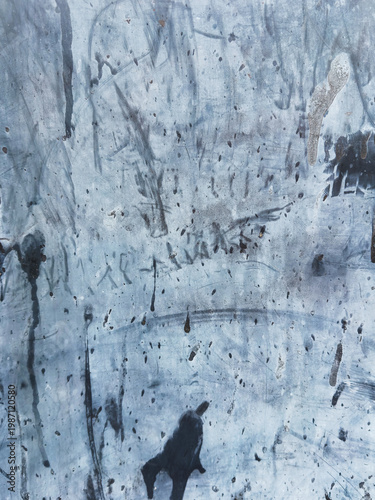 Weathered metal surface showing signs of wear and tear, creating abstract patterns