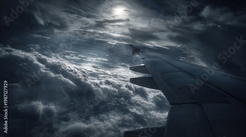 Airplane wing cuts through the sky above a thick layer of storm clouds under bright sunlight.