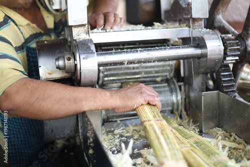 Sugarcane juice being squeezed from machine 