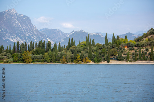 Picturesque view of Lake Garda, surrounded by the Alps mountain ranges, scenic cypresses, Lake Garda, Italy