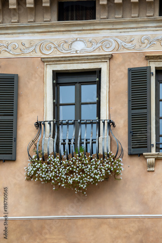 Decorative old townhouse facade, featuring ornate ironwork balcony and relief, Salo, Lake Garda, Italy