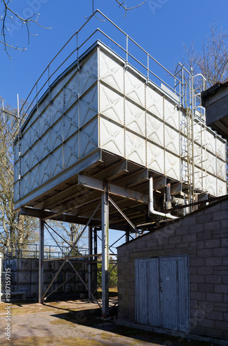 A side view of the Historical Steel Water Tanks at Stracathro Hospital Entrance, showing the riveted metal panels used in the construction.