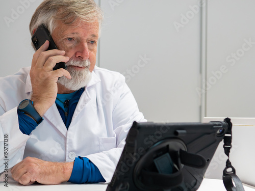 Doctor in white coat consults patient over phone during virtual appointment