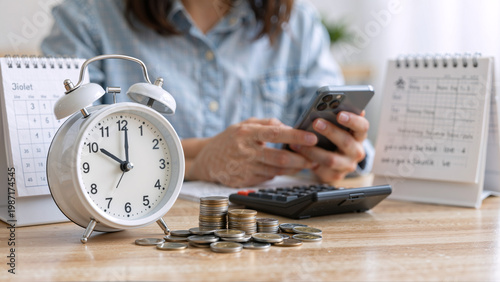 Bild auf Leinwand Person using phone with alarm clock and coins