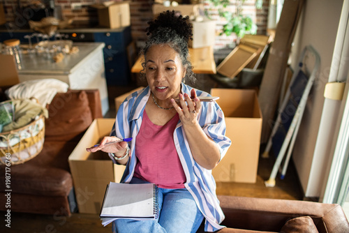 Senior woman planning a home move on phone at home