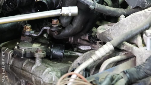Technician hand disassembles car underbonnet parts in repair shop closeup. Worker removes damaged detail of vehicle at service station
