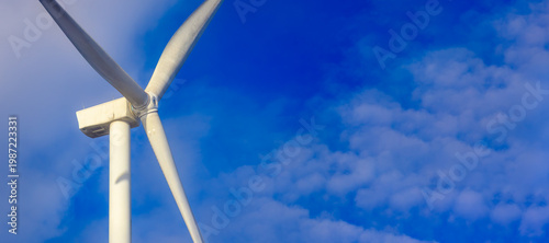 Close-up of wind turbine blades against a blue sky. Wind turbine used to generate electricity. Green renewable energy concept. Background with copy space