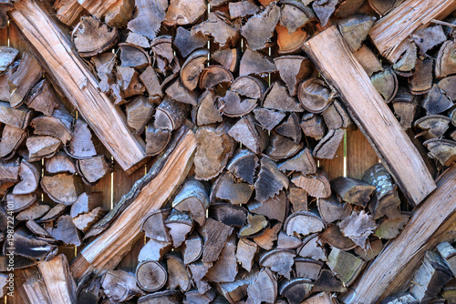 Close-up of textured background with firewood. Fragments of chopped wood weathered firewood and logs