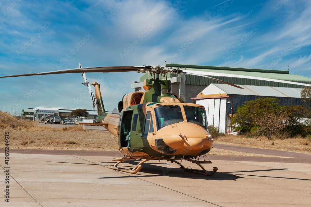 Fototapeta premium Military transport helicopter with desert camouflage parked on a tarmac