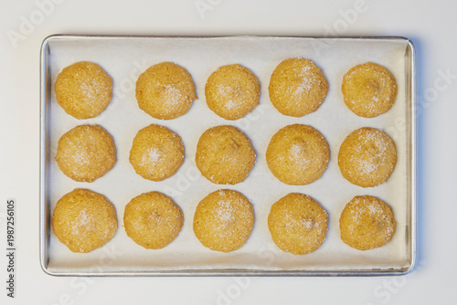 Homemade sugar cookies baking on parchment paper tray