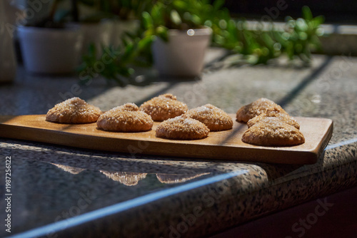 Homemade sugar cookies on wood board in morning light