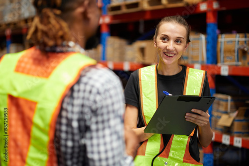 Workers collaborating while reviewing inventory management with each other in a warehouse storage