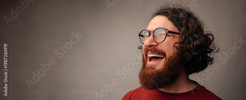 Man Laughing Heartily In Candid Closeup, Glasses And Beard Highlight Expressive Joy, Studio Lighting Captures