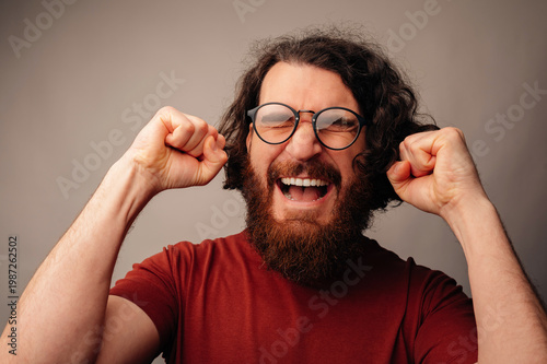 Man Celebrating Victory With Raised Fists And Triumphant Expression, Glasses On, Studio Closeup, Energetic