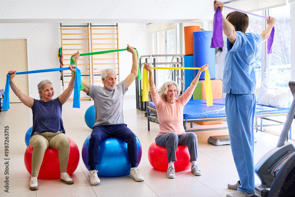 Obraz premium Senior Adults Doing Exercises With Resistance Bands On Exercise Balls In Rehab Center With Physiotherapist Supervising For Rehabilitation