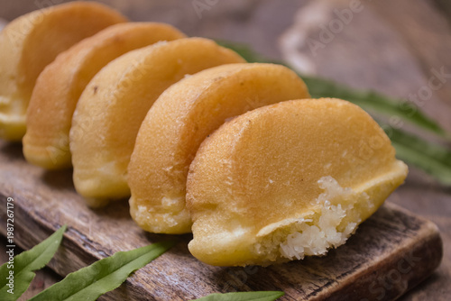 Freshly Baked Indonesian Kue Pukis – Traditional Golden Sweet Street Food Snack Served on a Rustic Wooden Board